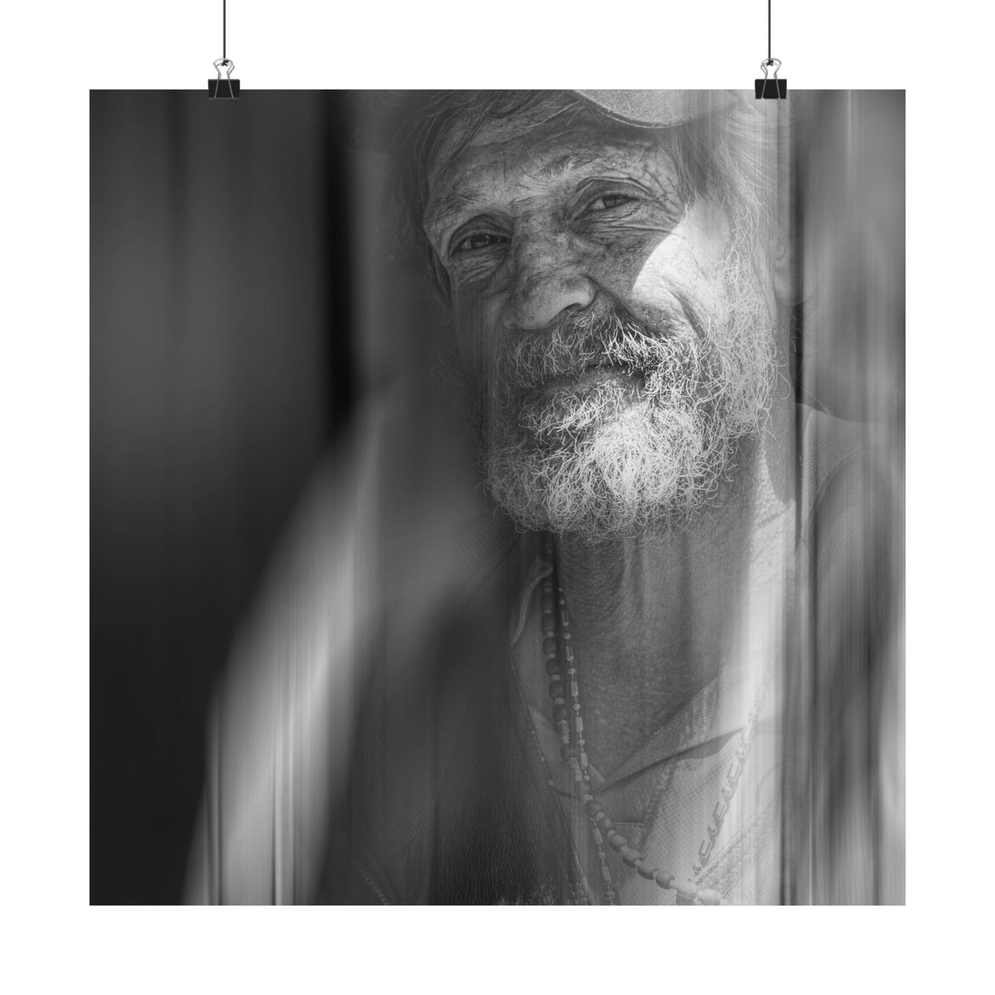Black and white portrait of an elderly man with a beard and a necklace.