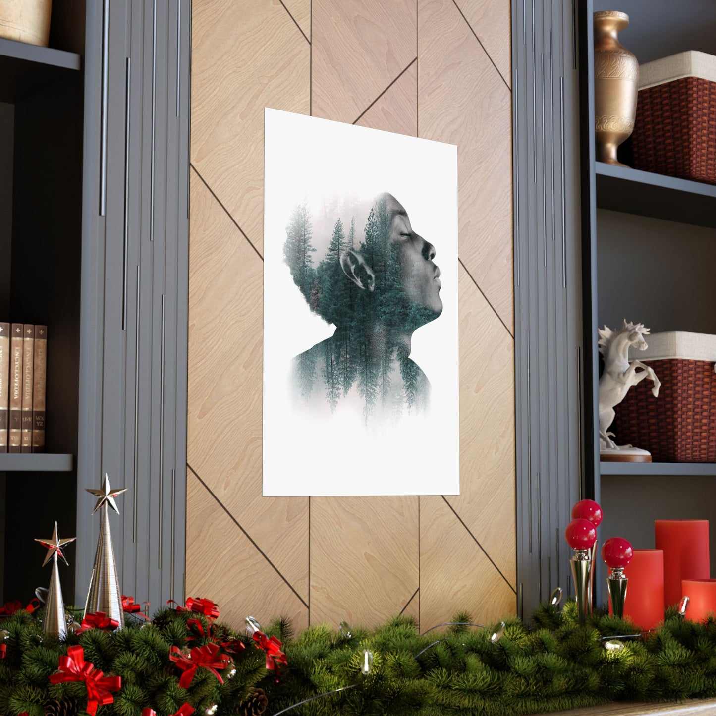 Framed artwork of a silhouette with nature theme on a wall with festive decorations below.