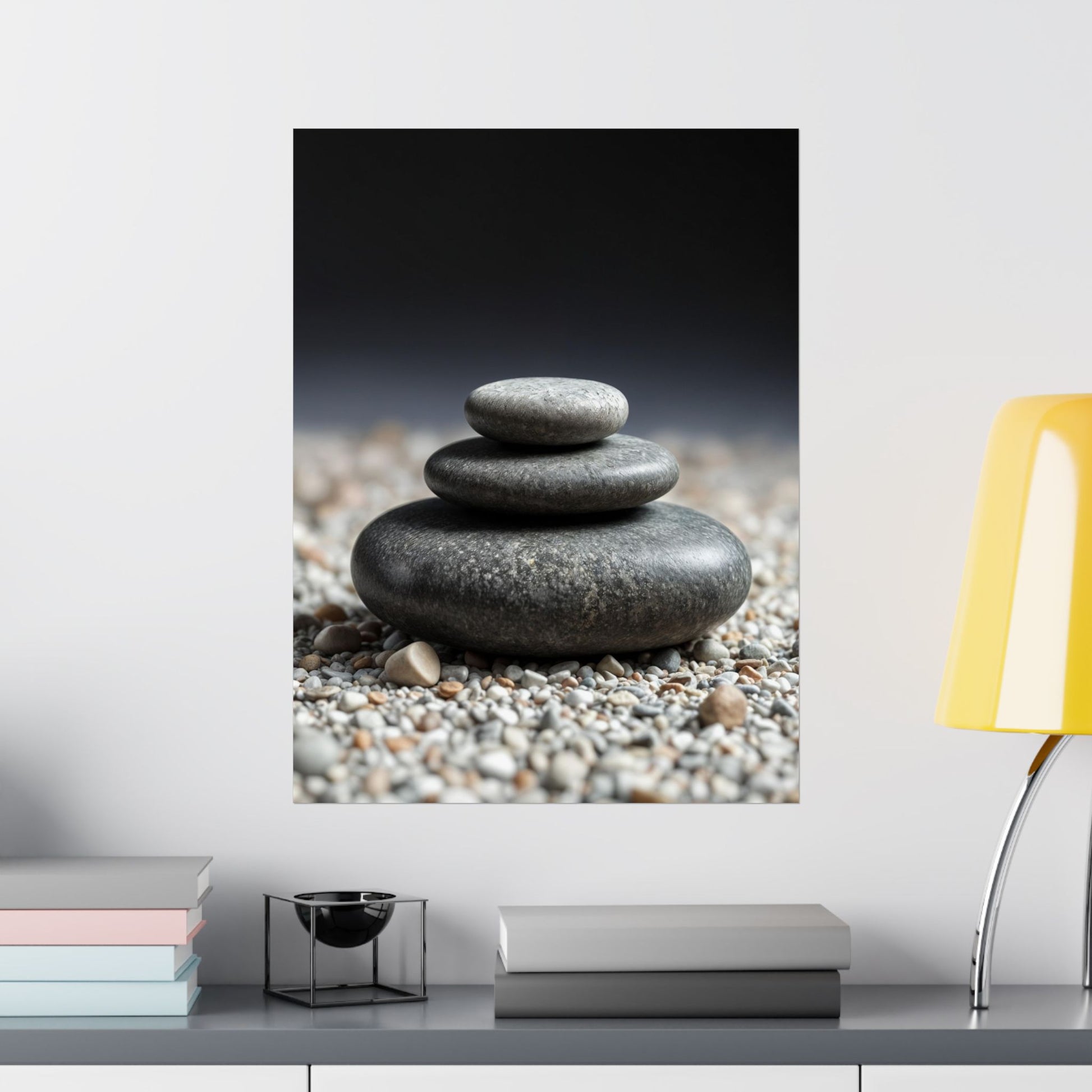 Stylized image of stacked stones on pebbles with a blurred background, displayed on a wall above a shelf.