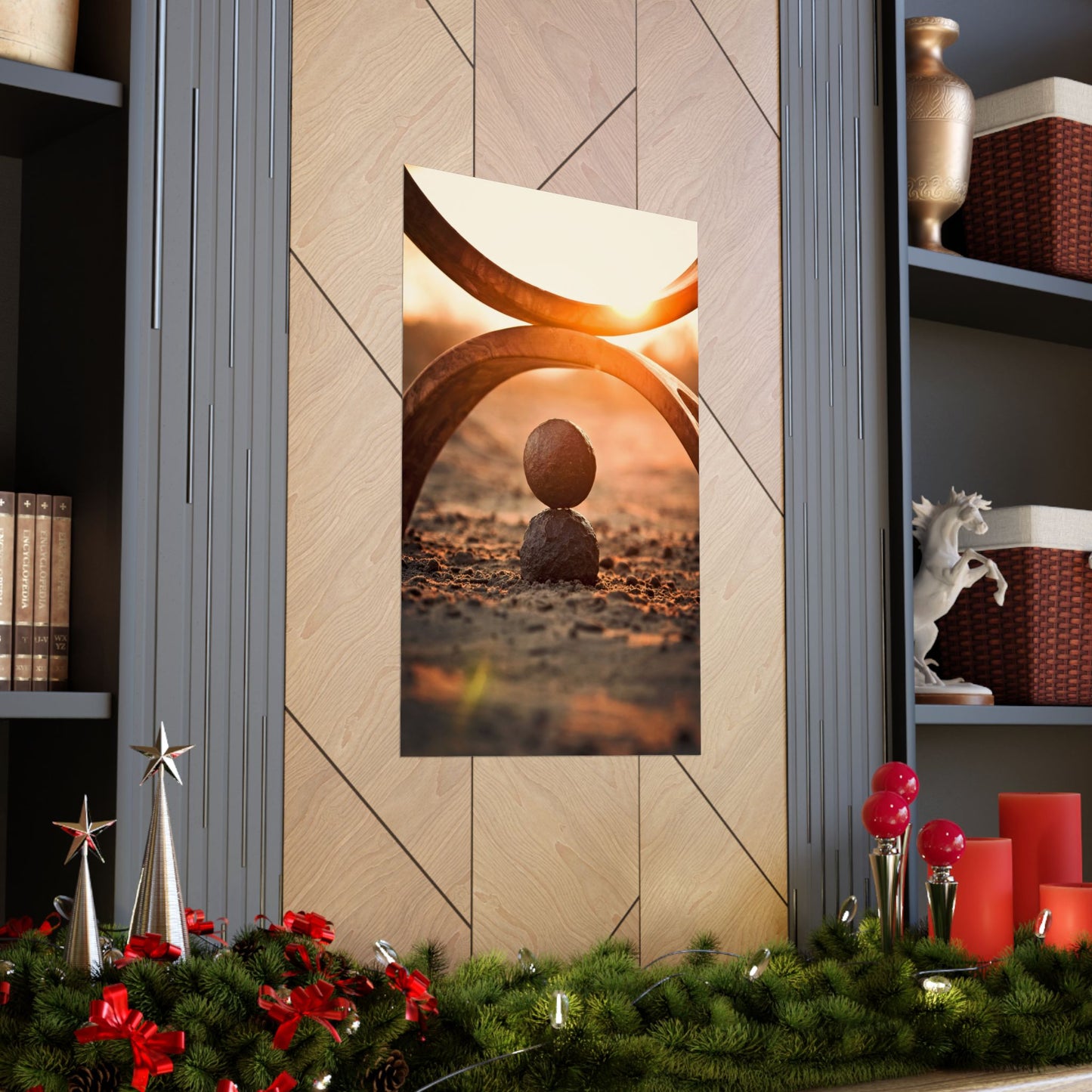 Decorative wall art of two stones balanced against a sunset sky, displayed on a wall with festive decorations at the bottom.