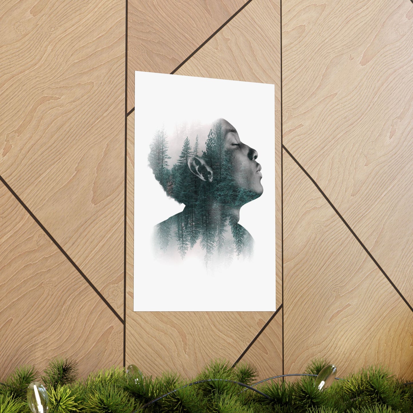 Framed artwork of a person with trees superimposed on their head, leaning against a wooden wall.