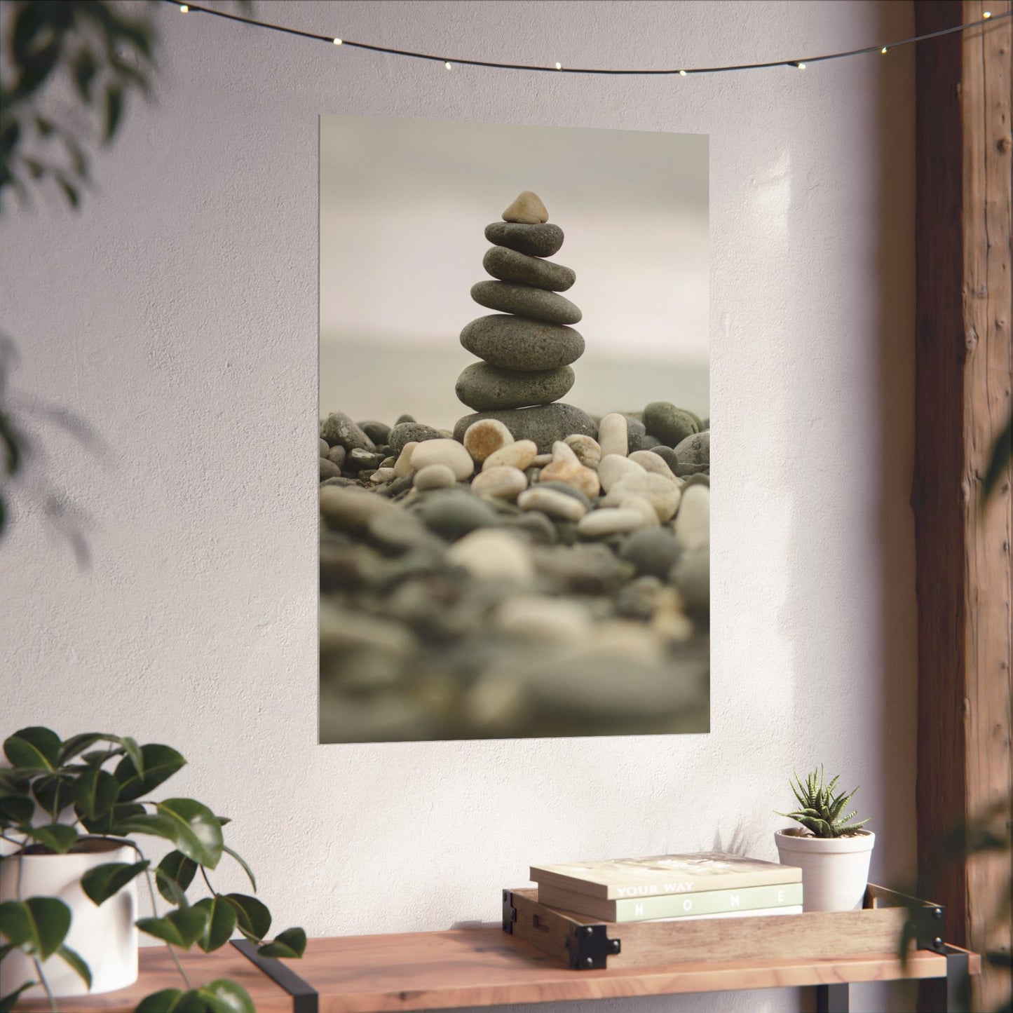 Stylized image of stacked stones on a wall with plants and books below.