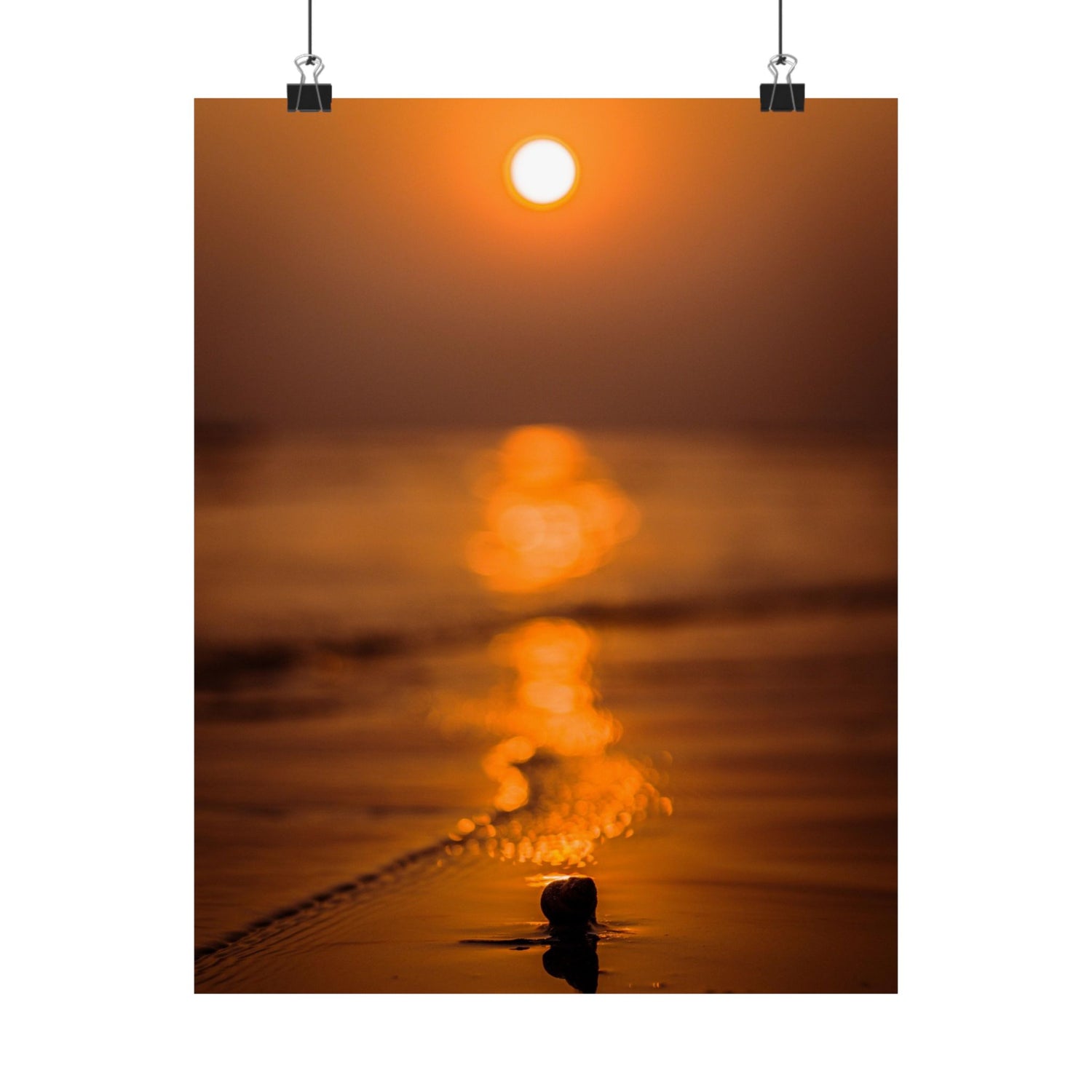 Sunset over water with a person standing in the foreground