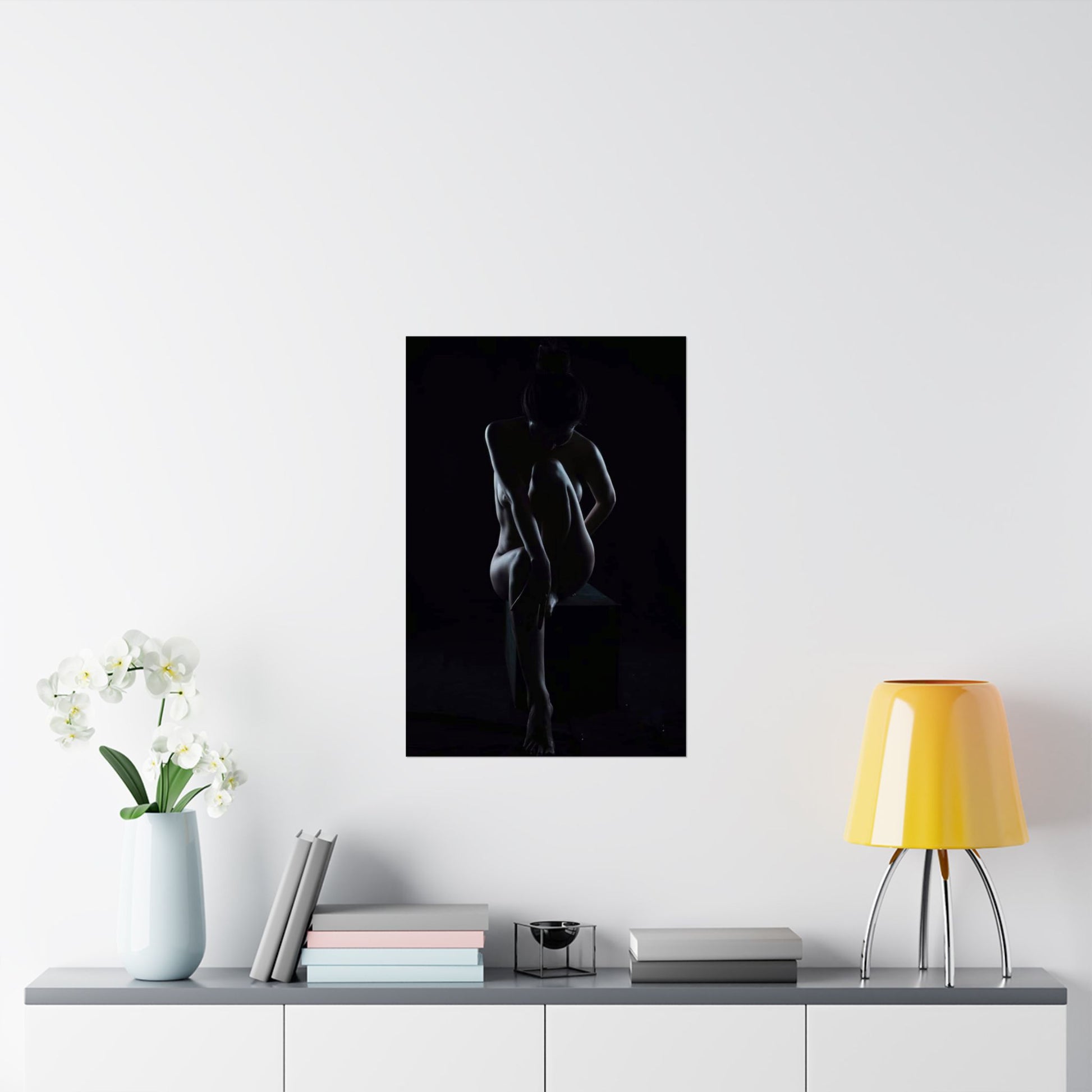 Silhouette art print on a wall above a table with decor items.