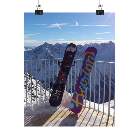 Two snowboards against a mountainous landscape with a clear blue sky.