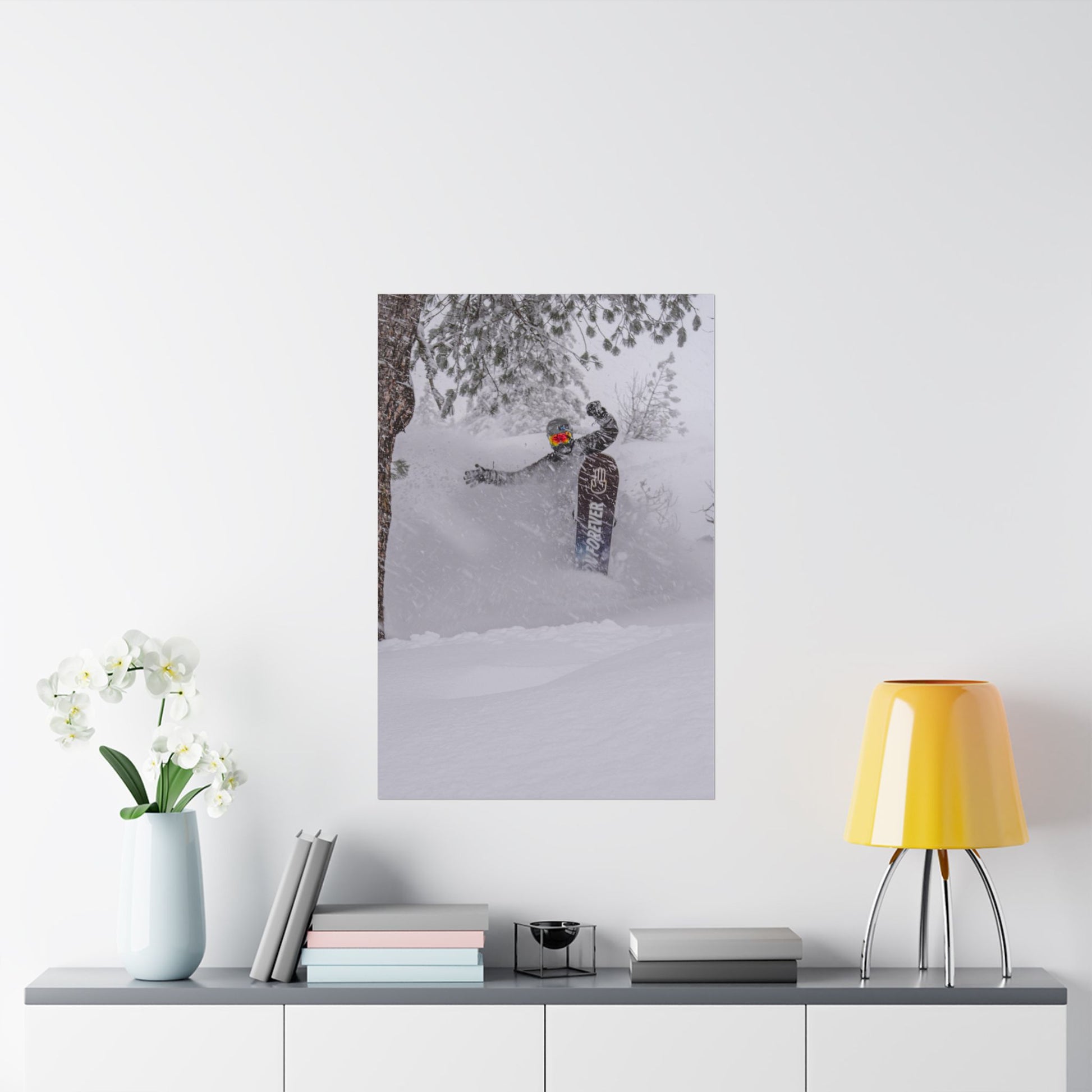 Poster of a person snowshoeing in a snowy landscape on a wall above a shelf with decor items.