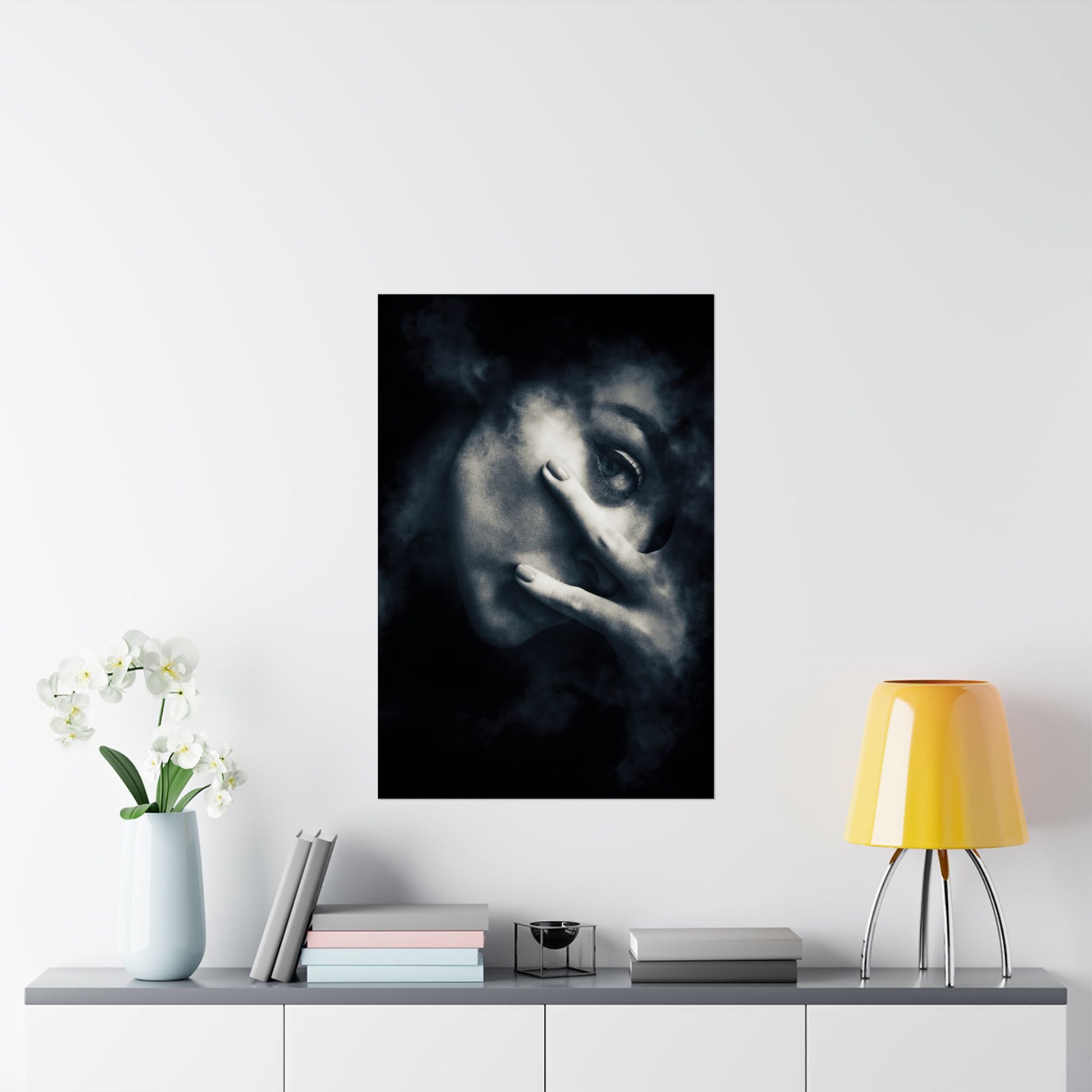 Framed artwork of a woman's face on a wall above a shelf with decor items.