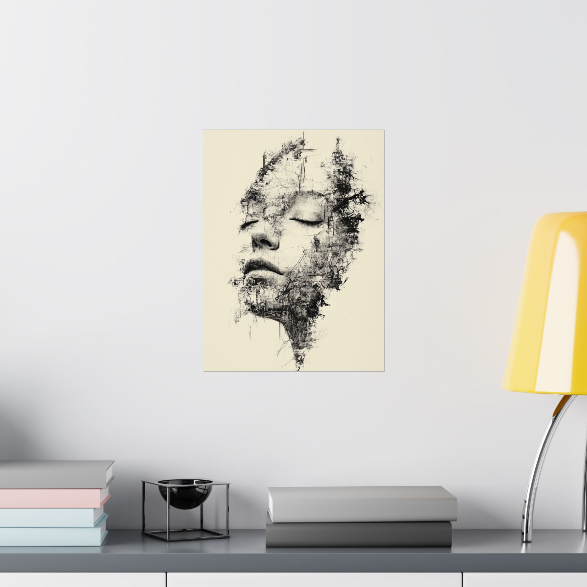 Abstract art print of a face on a wall above a shelf with books and a lamp.