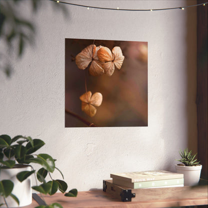 Wall art of dried flowers on a white wall with plants and books below.