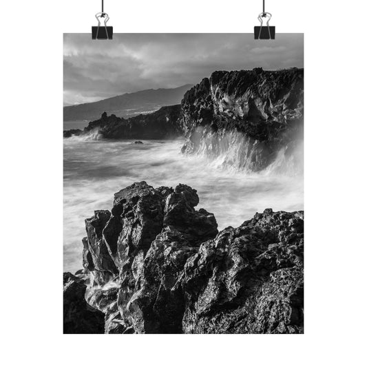 Black and white photograph of a rocky coastline with waves crashing against the rocks.