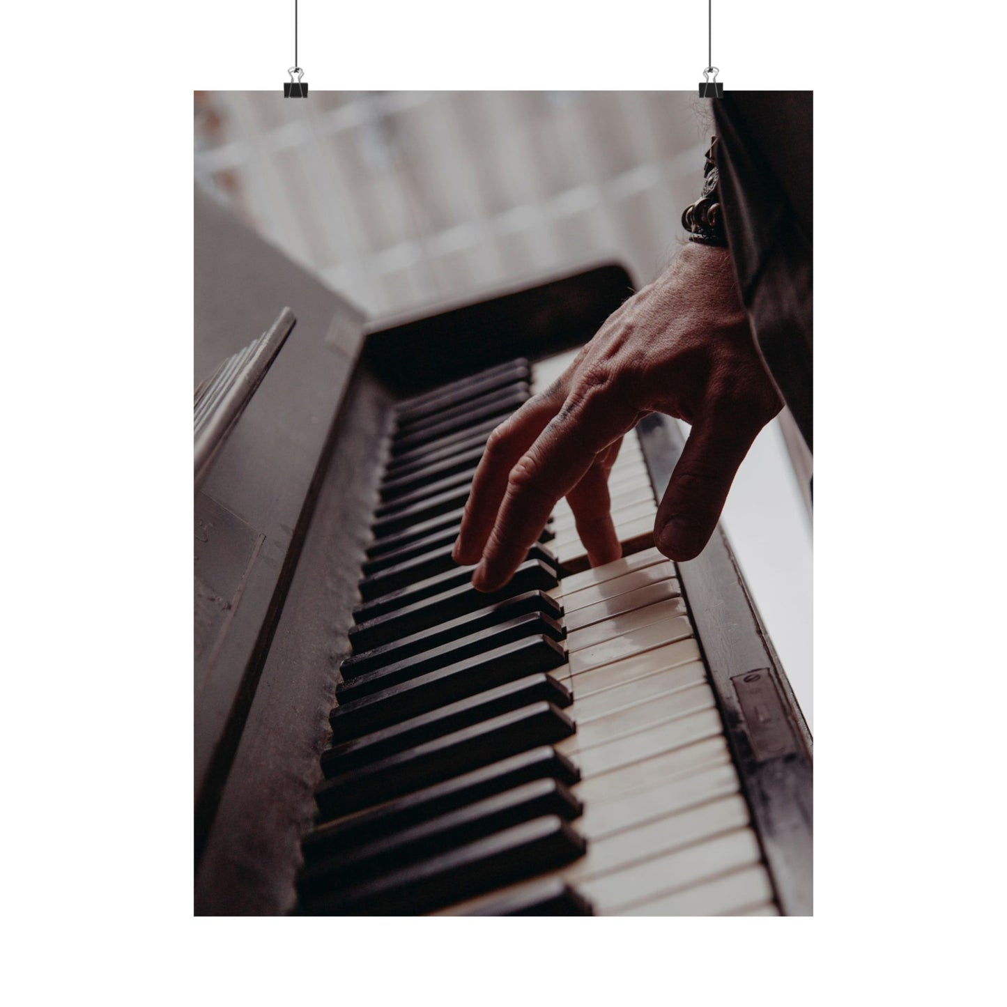 Hand playing piano keys with a blurred background