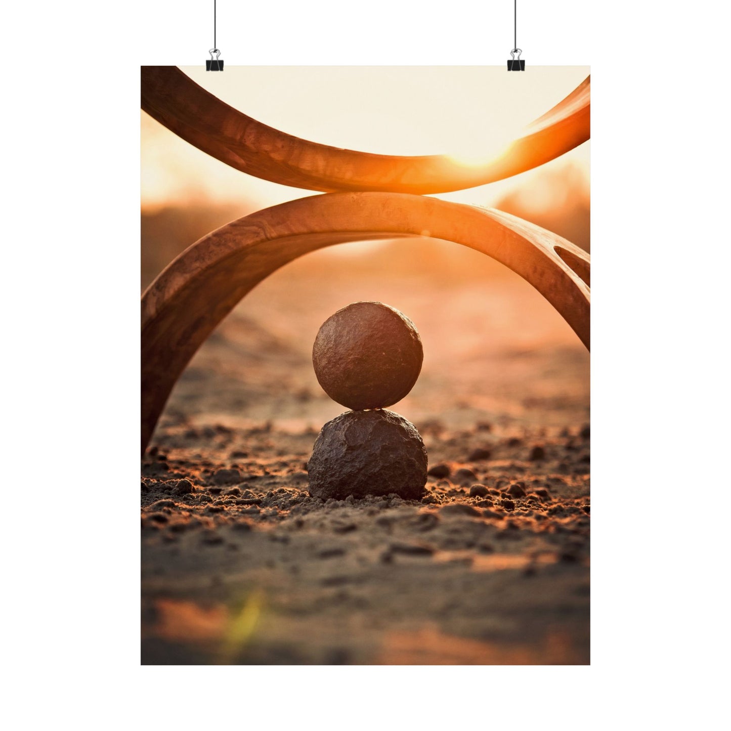 Two stones balanced on each other with abstract curved lines and a warm glow in the background