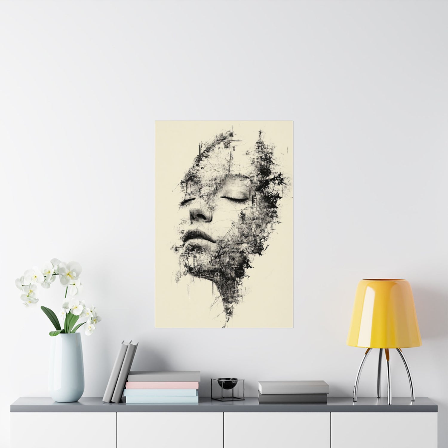 Abstract art print of a face on a wall above a table with decor items.