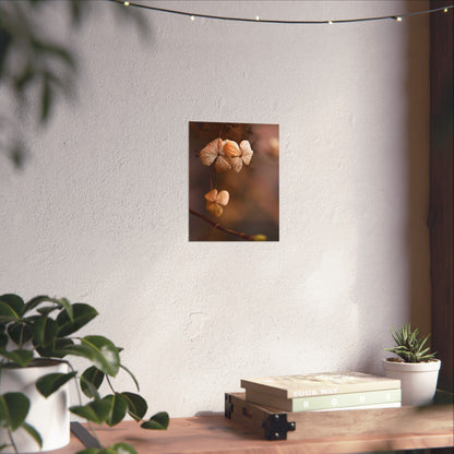 Decorative wall art of flowers on a white wall with plants and books on a table below.