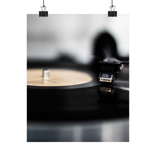 Close-up of a vinyl record player with a record on a dark surface.