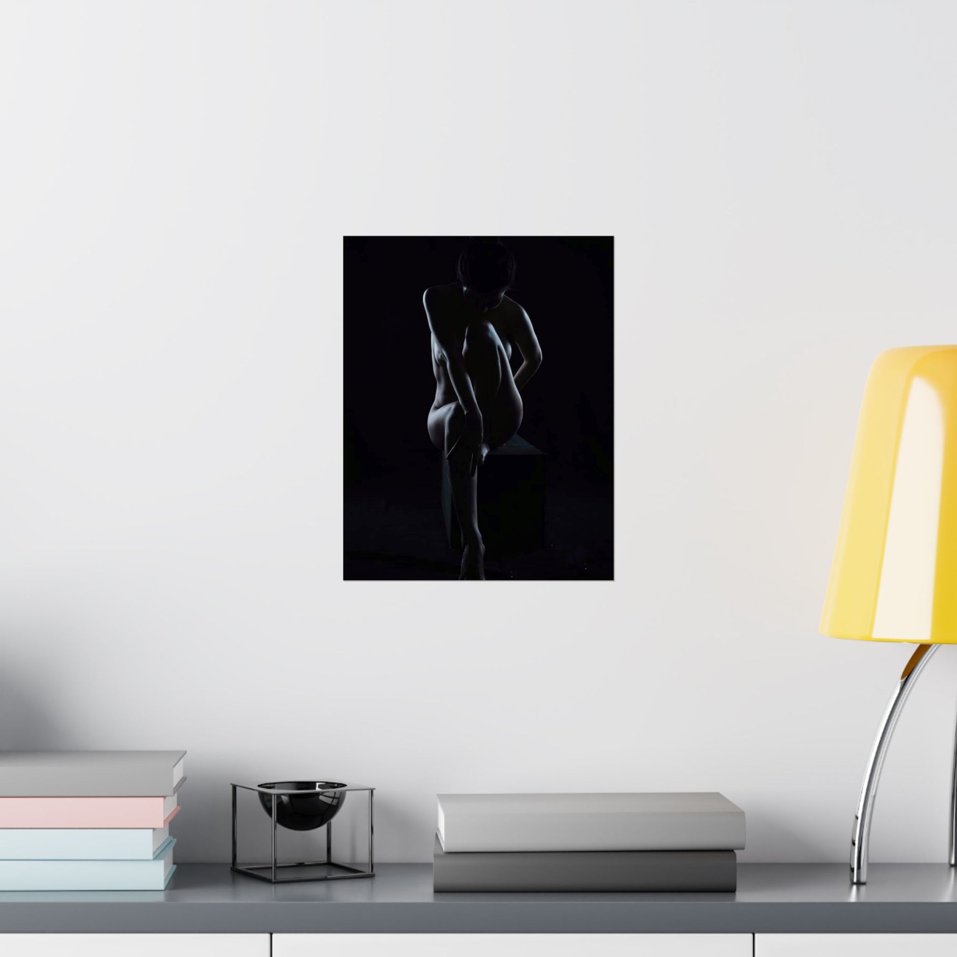 Silhouette of a person against a black background on a wall above a shelf with books and a lamp.