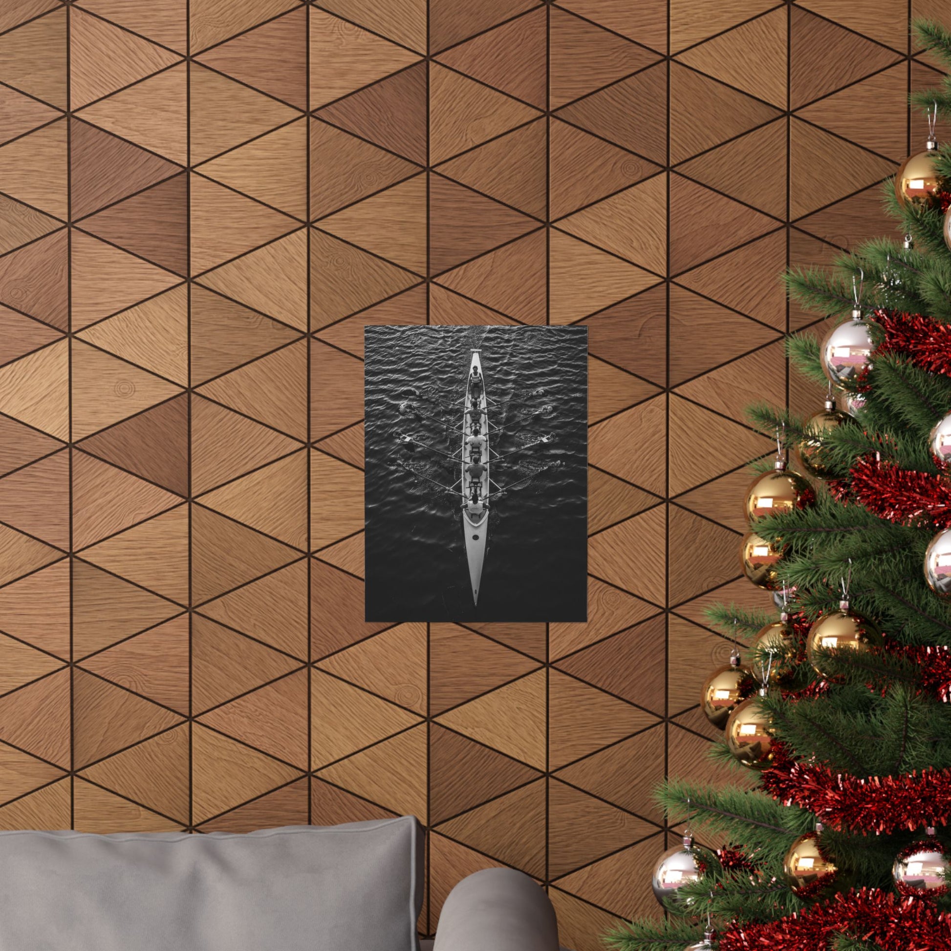 Wooden wall with geometric pattern, framed picture of a boat, and Christmas tree with decorations.