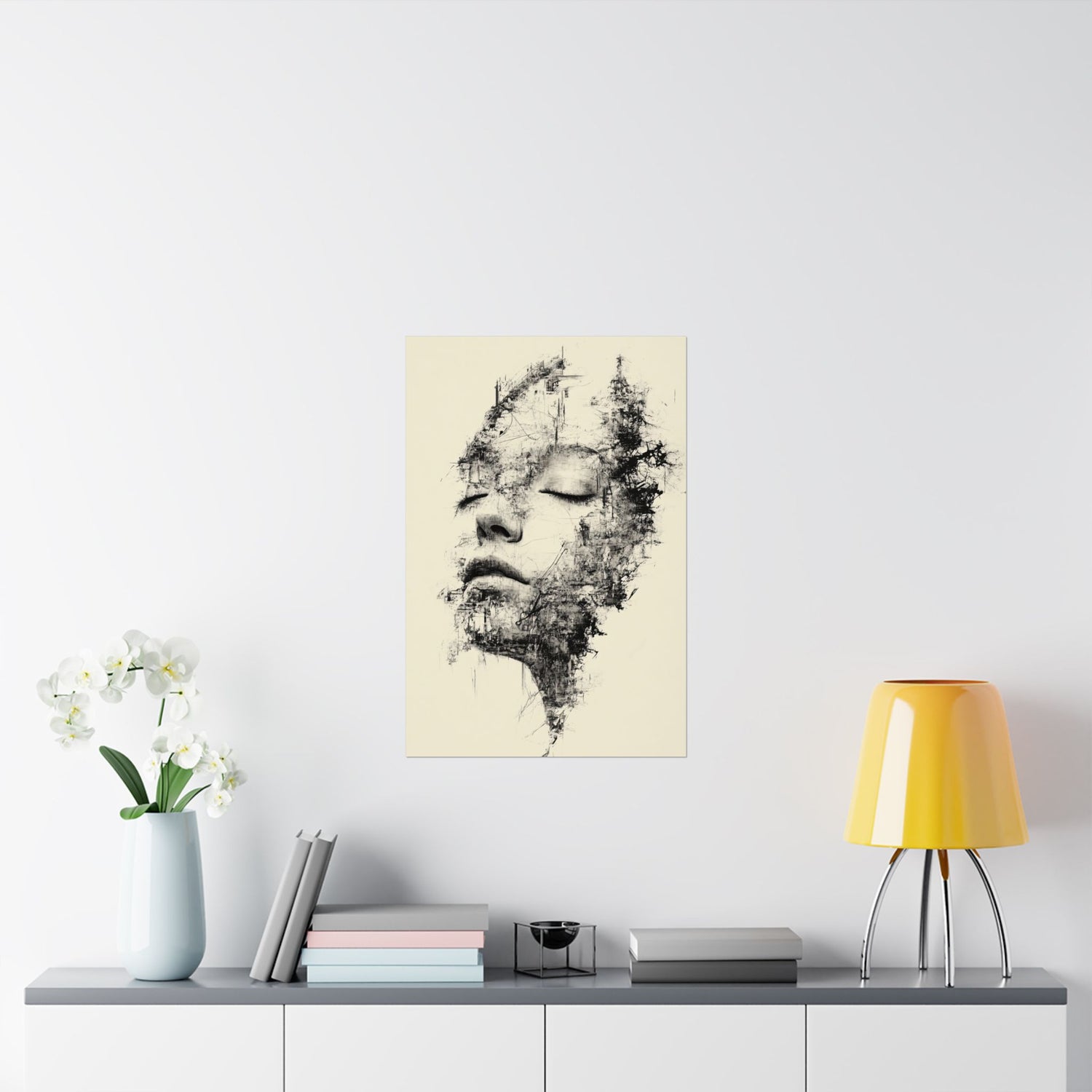 Abstract art print of a face on a wall above a table with decor items.