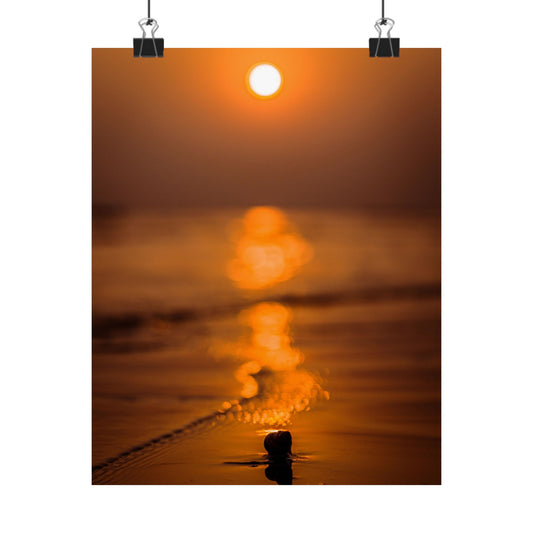 Sunset over water with a person standing in the foreground