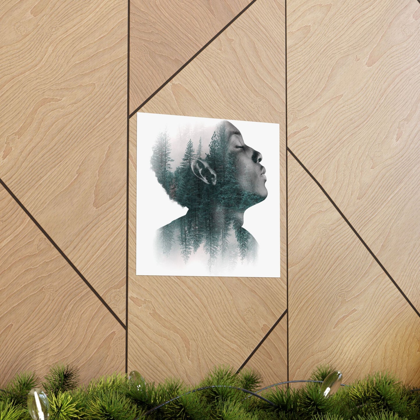 Art print of a person with trees superimposed on their hair, displayed on a wooden wall.
