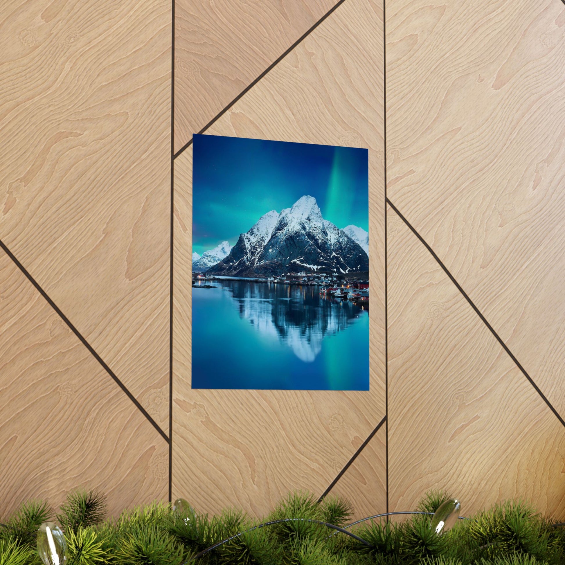 Poster of a mountain landscape with water and Northern Lights on a wooden wall.