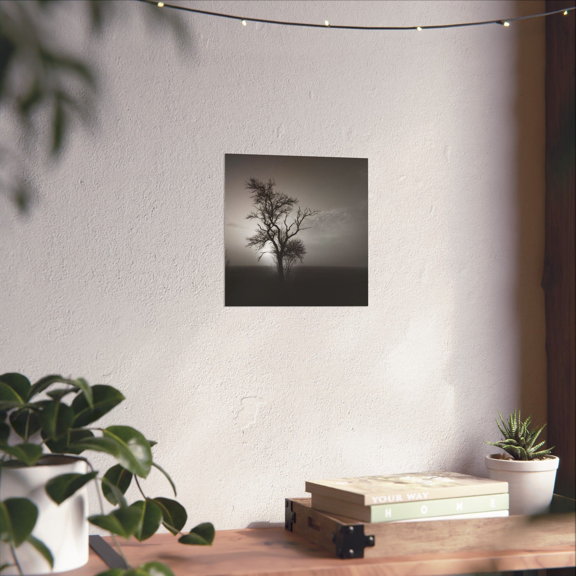 Poster of a tree on a wall with a table and plants in the foreground