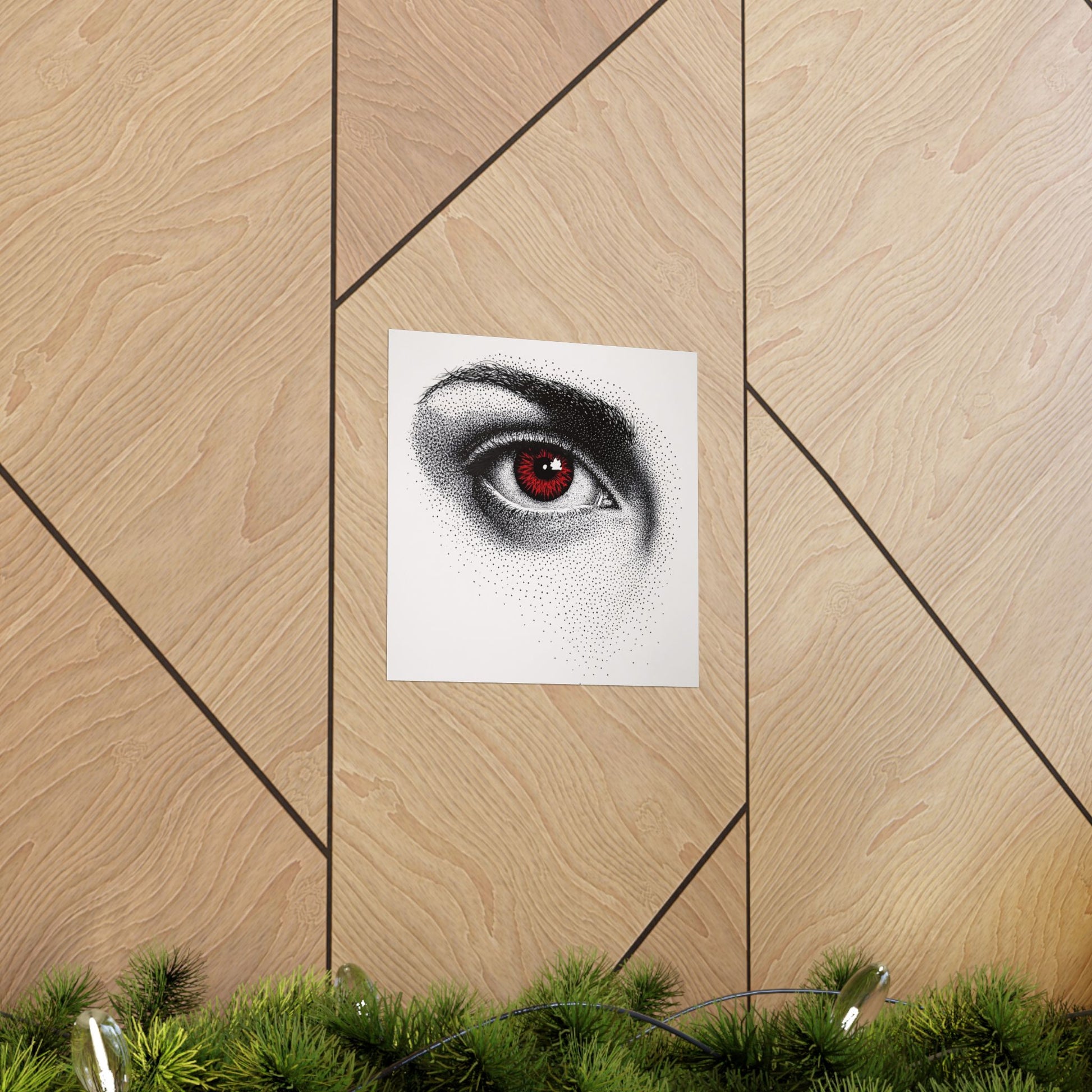 Poster of a stylized eye with red detailing on a wooden floor.