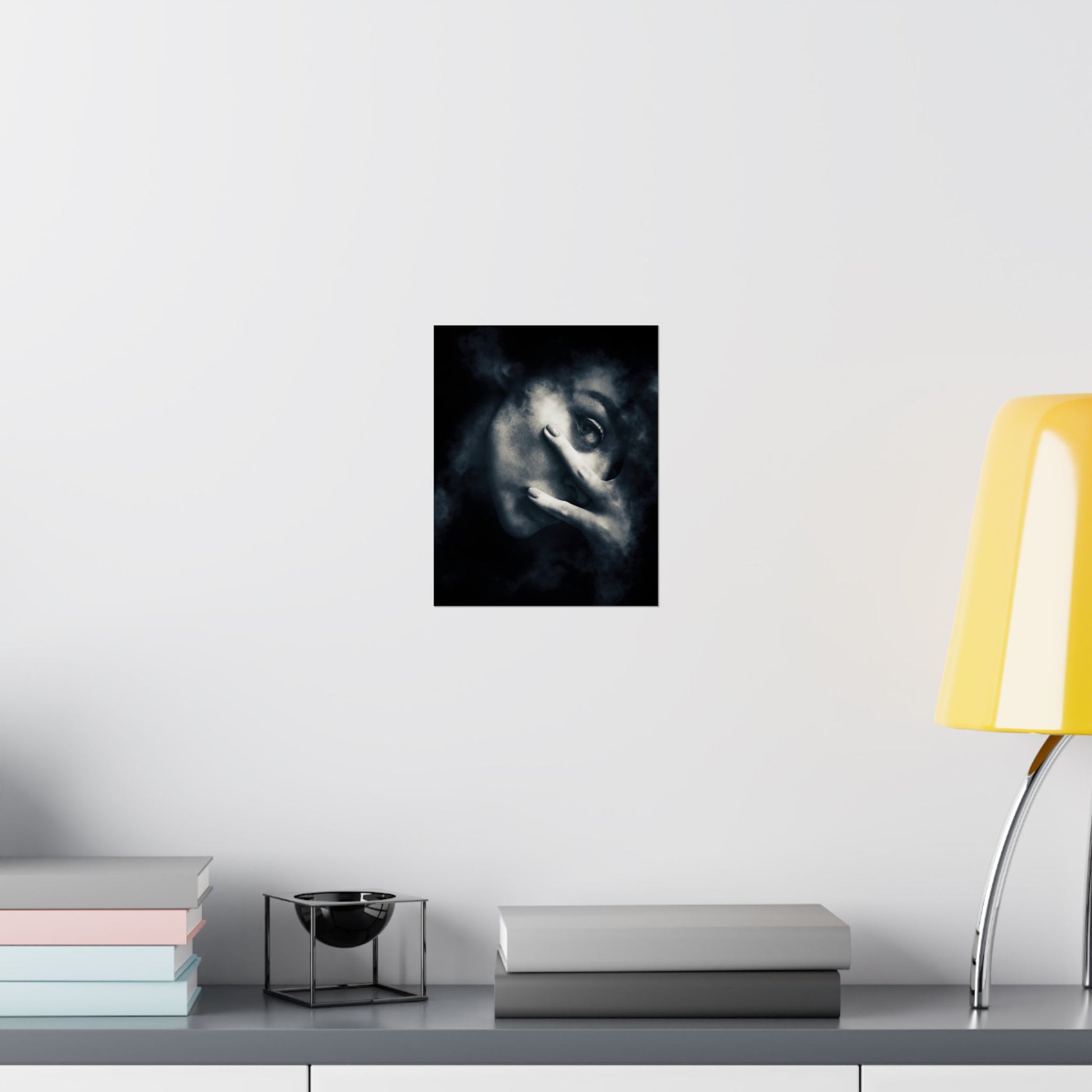 Framed artwork of a wolf's face on a wall above a desk with books and a lamp.