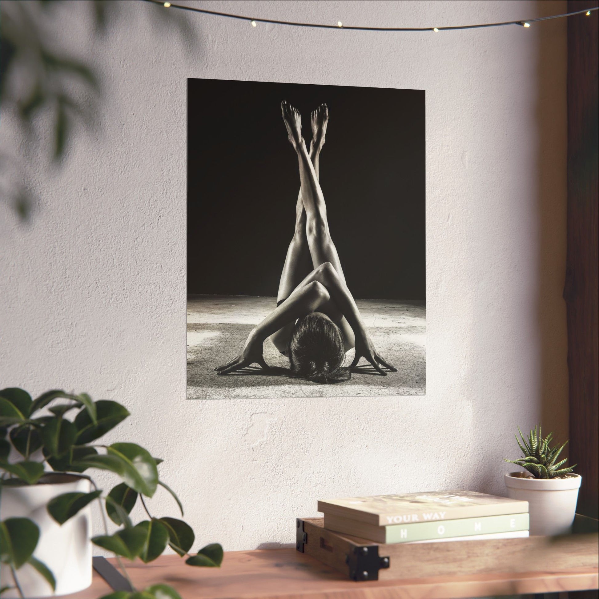 Yoga-themed wall tapestry with a person in a headstand on a white wall, with a table and plants in the foreground.