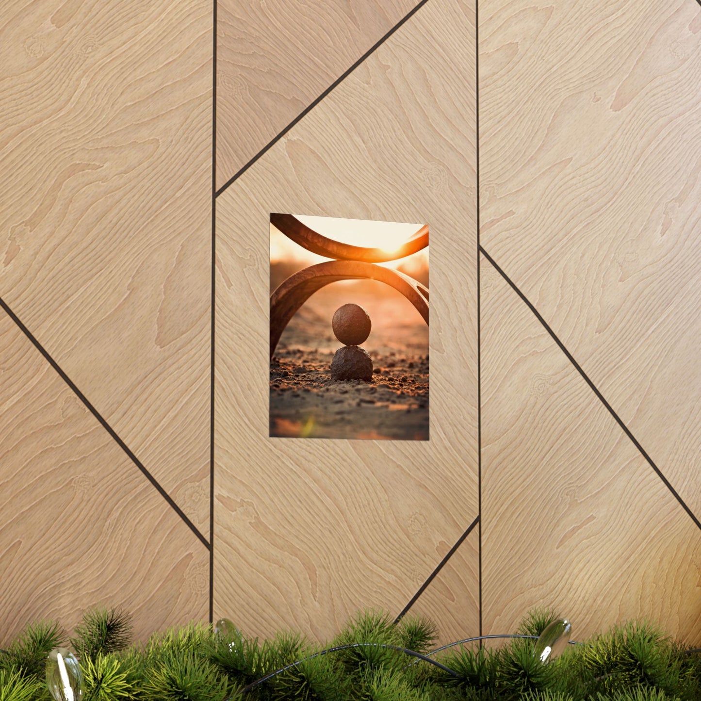 Framed artwork of two stones with a sunset background on a wooden wall.