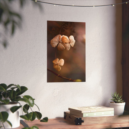 Decorative wall art of dried flowers on a white wall with plants and books below.