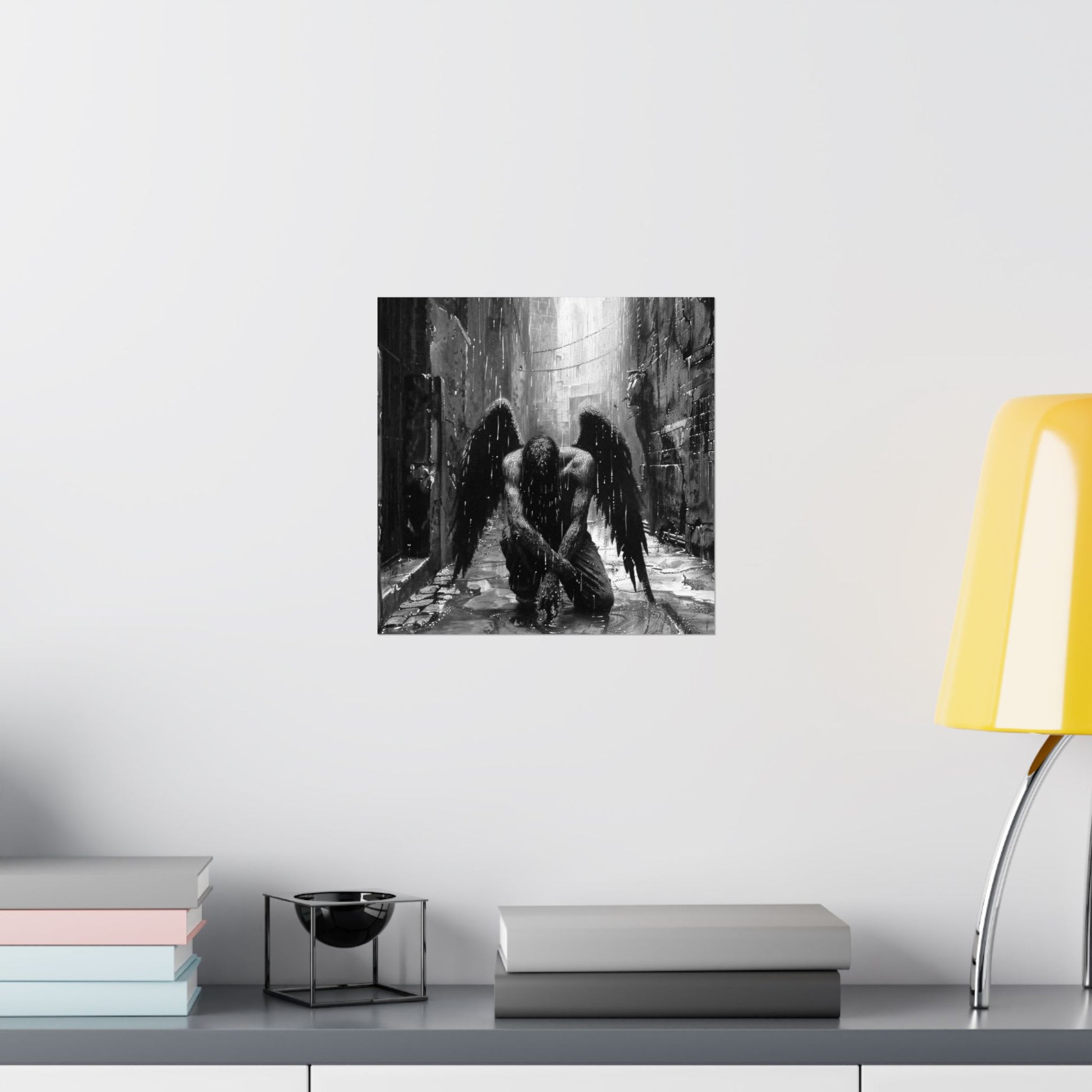Black and white artwork of an angel on a wall above a shelf with books and a lamp.