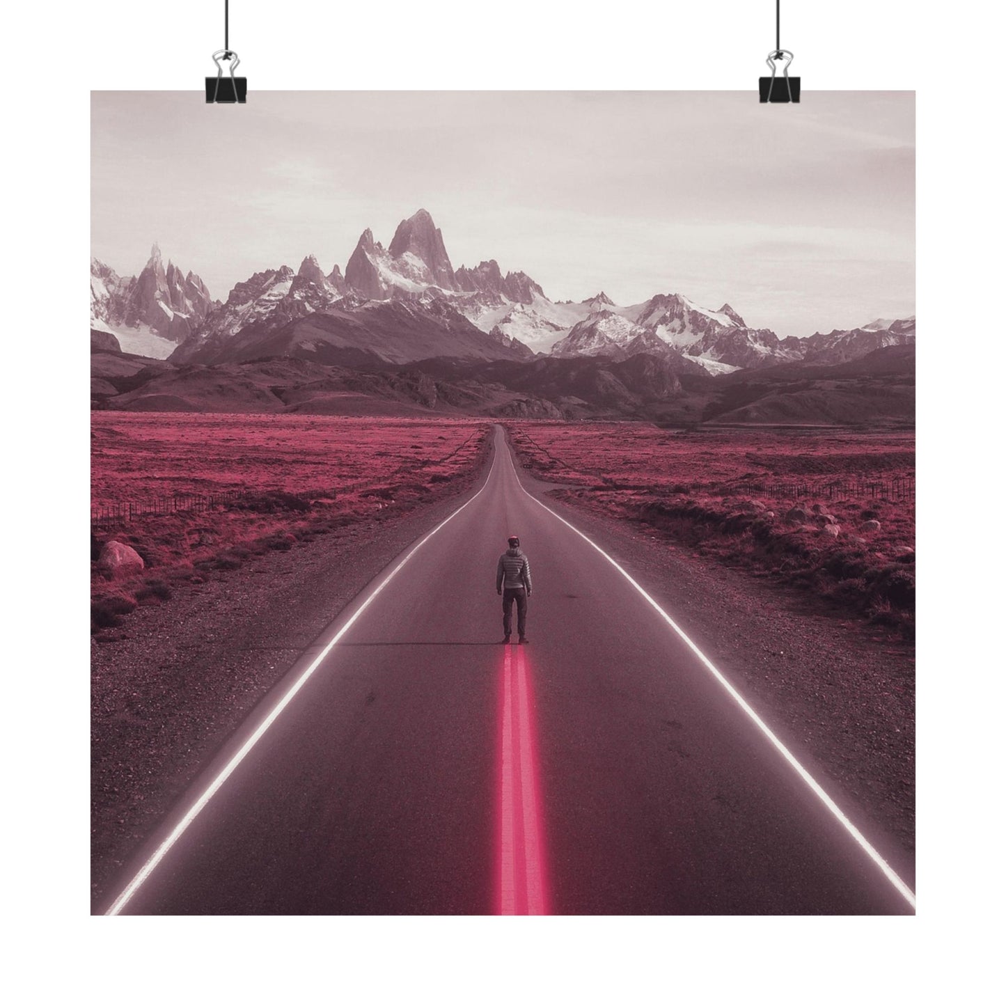 Person standing on a road with pink neon lights leading towards snow-capped mountains.