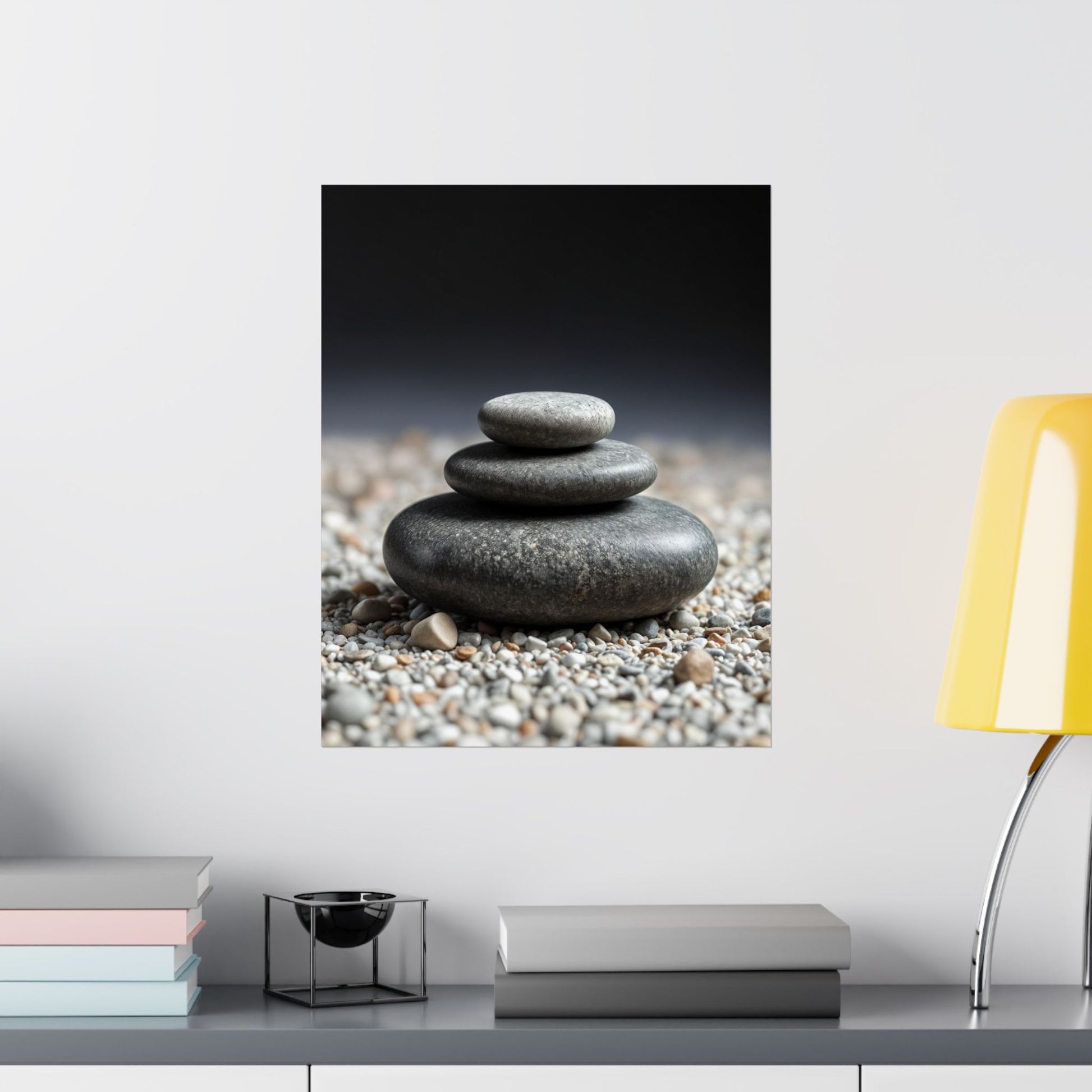 Stylized image of stacked stones on pebbles with a blurred background, displayed on a wall above a shelf.