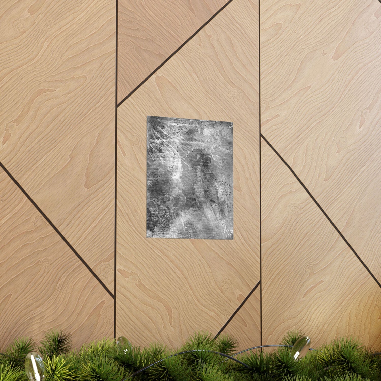 Decorative wall art on a geometric wooden panel with greenery at the bottom.