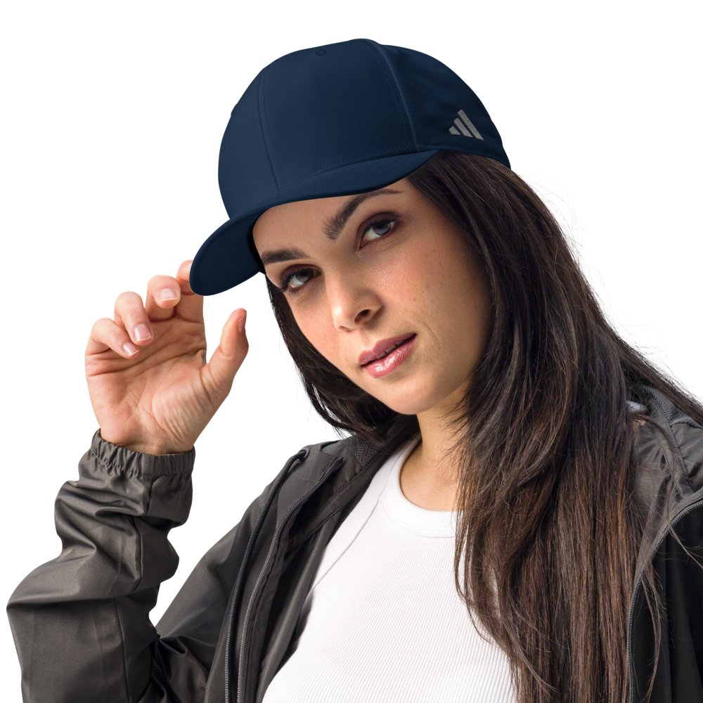 Woman wearing a navy blue Adidas cap on a white background