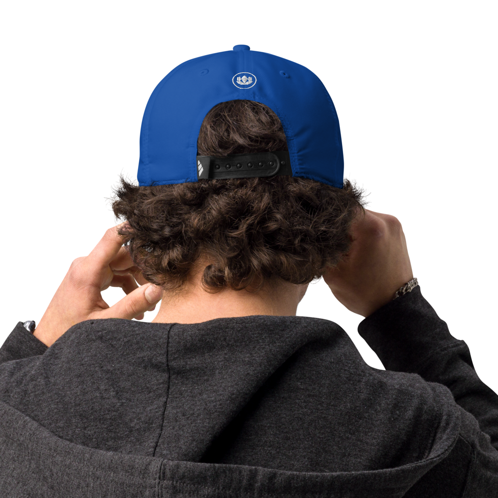 Person wearing a blue cap with a logo on the back, standing against a white background