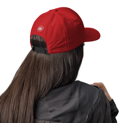 Person wearing a red cap with a logo on a white background