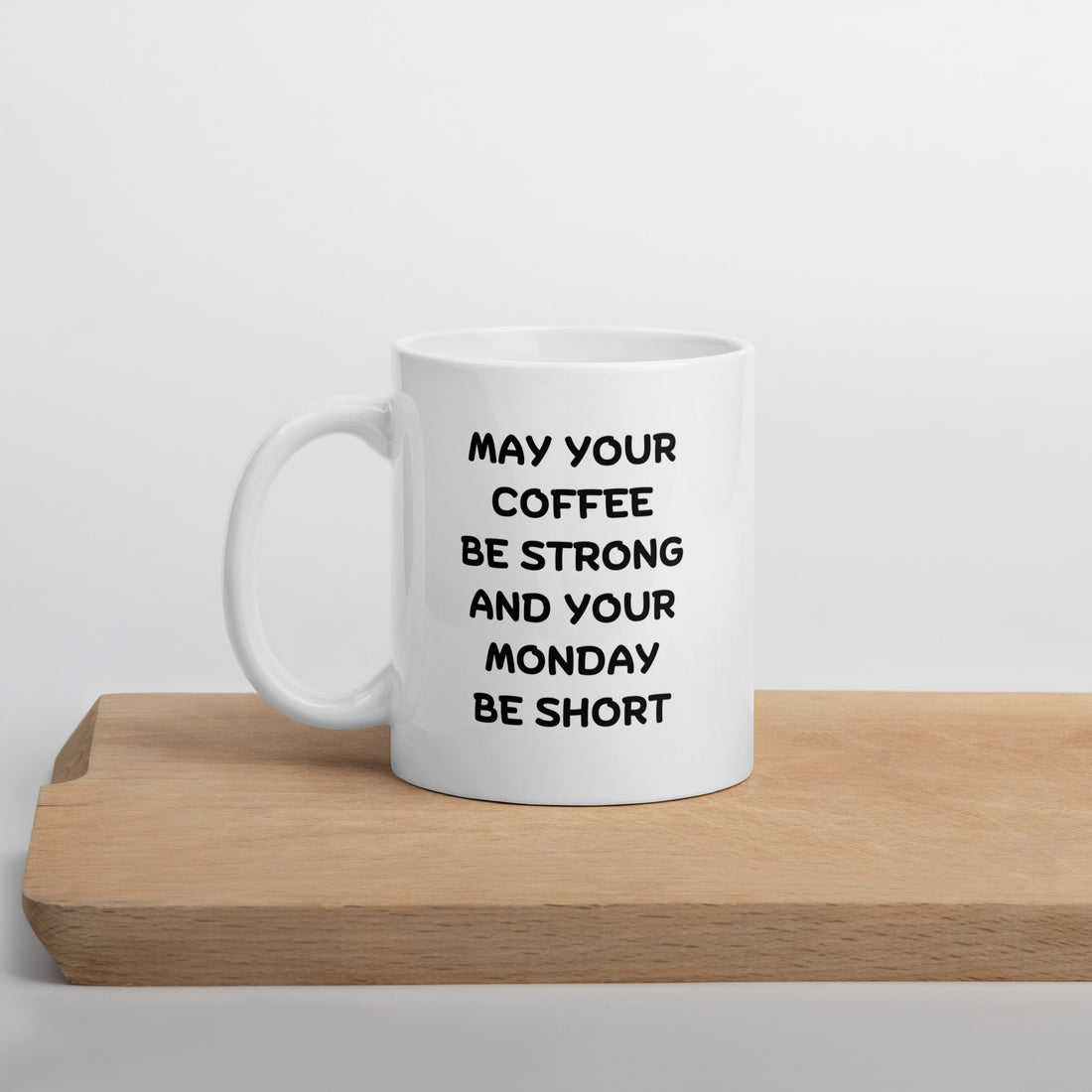 A white ceramic coffee mug with black text reading &