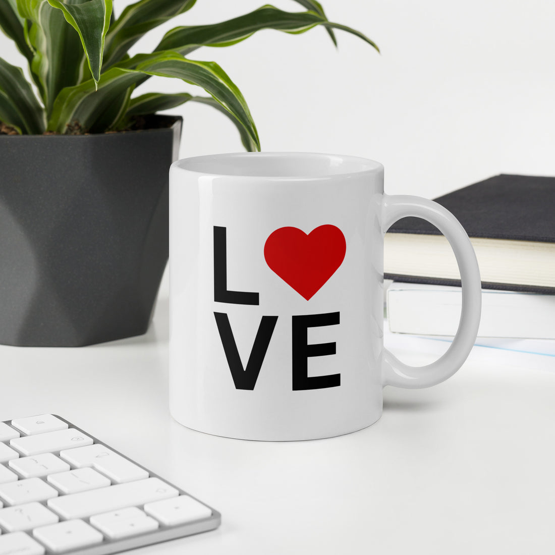 "White ceramic coffee mug with black text saying Love with red heart symbol"