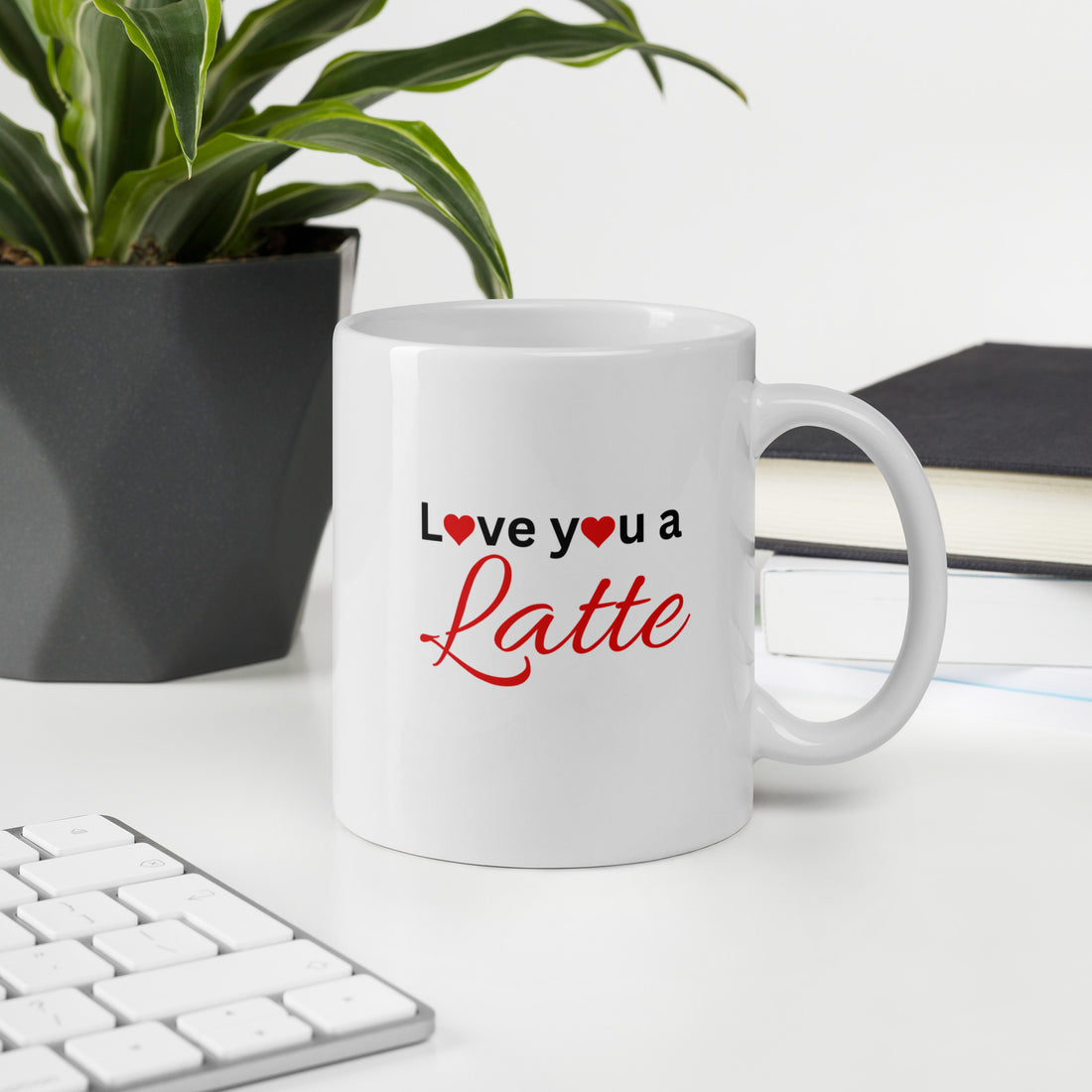 "White ceramic coffee mug with black text saying Love You a Latte with heart"