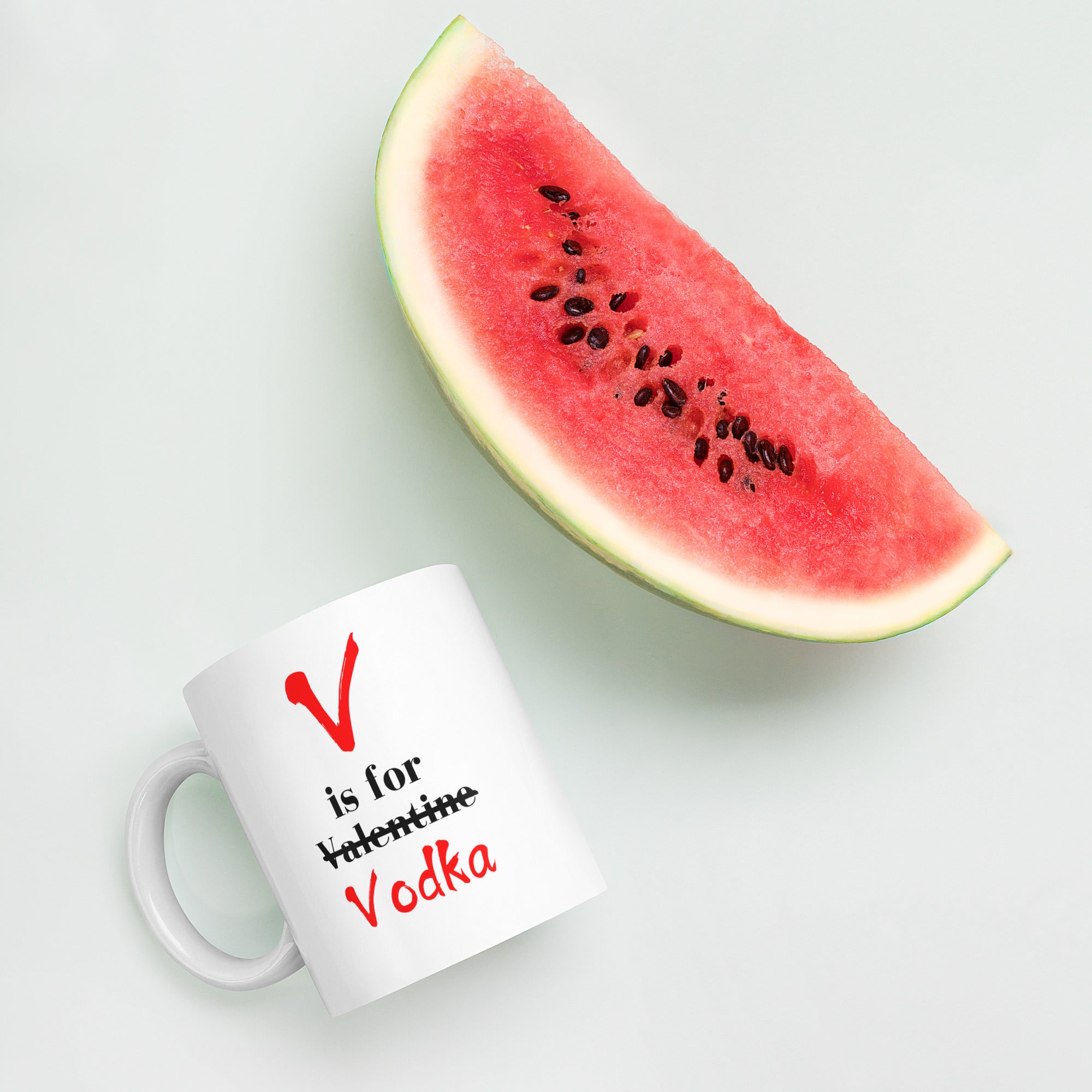 "White ceramic coffee mug with black text saying V Is For Valentine crossed out Vodka"