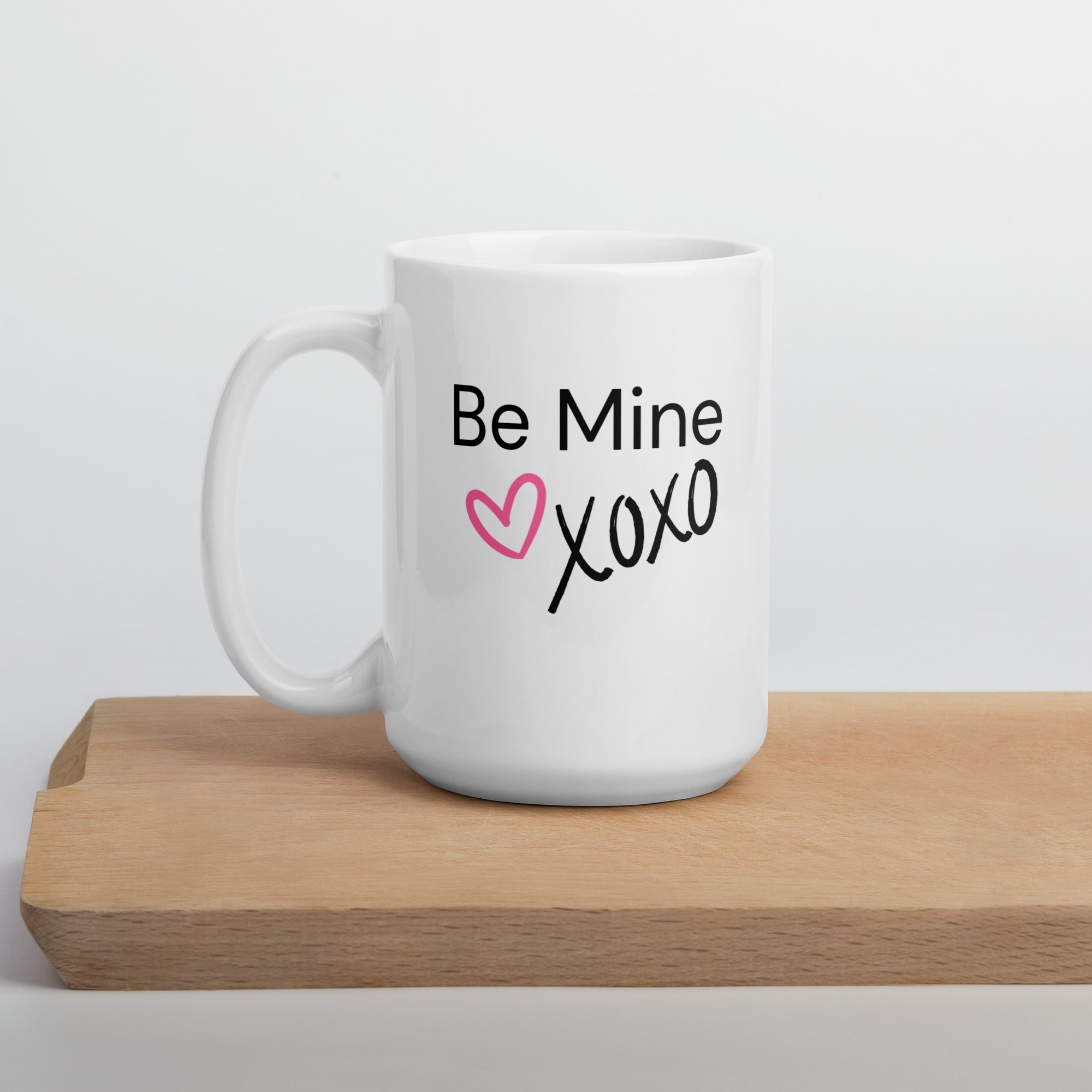 White ceramic coffee mug with black text saying Be Mine xoxo