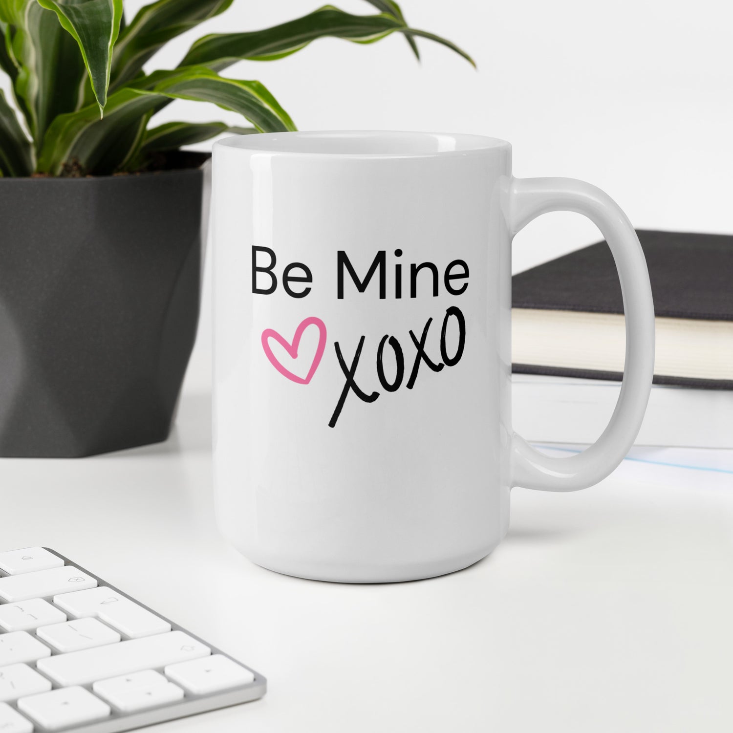 White ceramic coffee mug with black text saying Be Mine xoxo