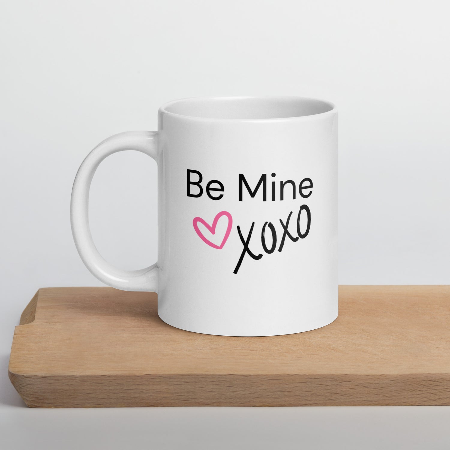 White ceramic coffee mug with black text saying Be Mine xoxo